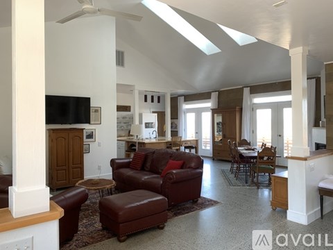 A living room with a brown leather sofa and a television.