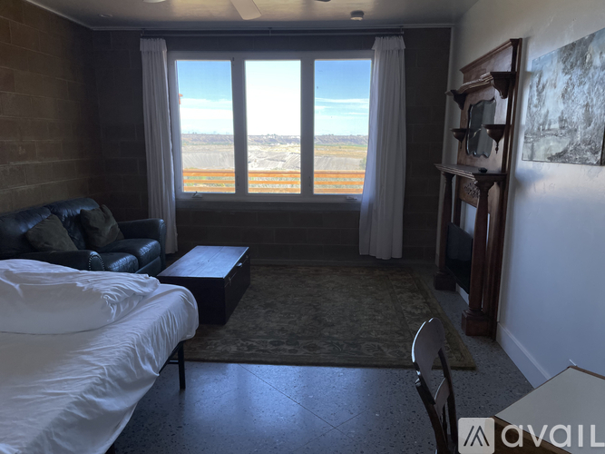 A bedroom with a large bed and a view of the desert outside the window.