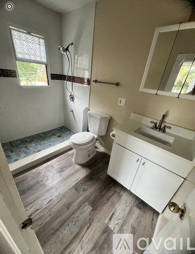 A bathroom with a toilet, sink, and shower.