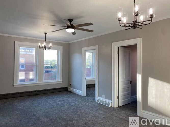 A room with a ceiling fan and a chandelier.