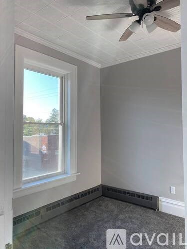 A room with a ceiling fan and a window.