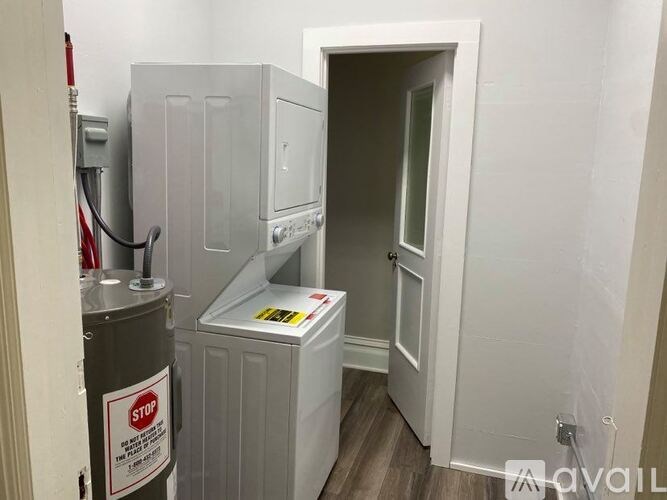 A room with a white door and a white fridge.