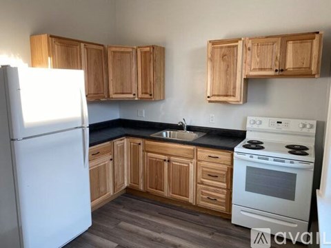 A kitchen with wooden cabinets and a white refrigerator.