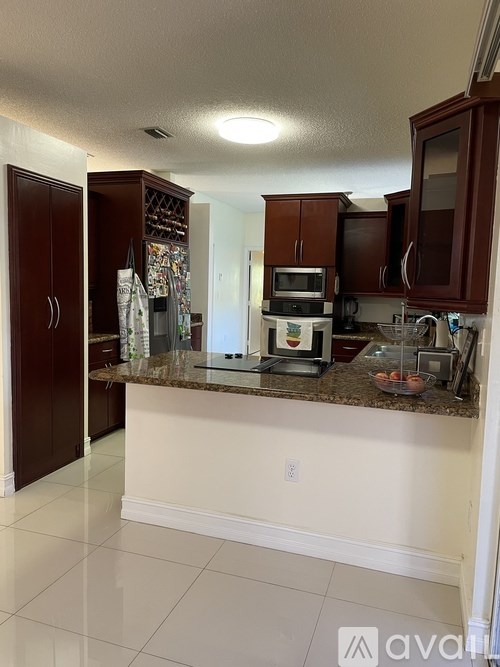 A kitchen with brown cabinets and a granite countertop.