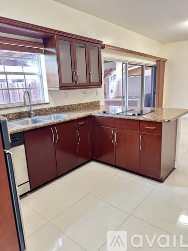 A kitchen with brown cabinets and a wooden table.