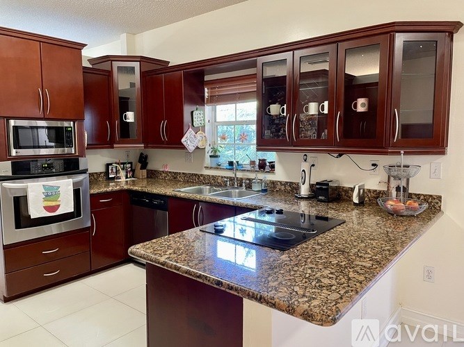 A kitchen with brown cabinets and granite countertops.