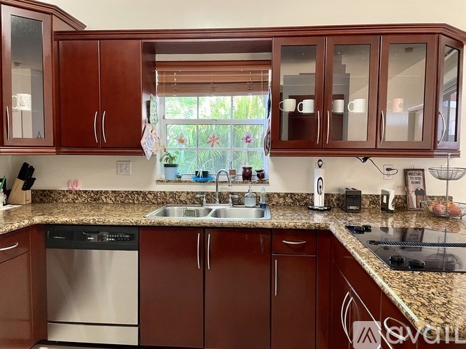 A kitchen with brown cabinets and granite countertops.