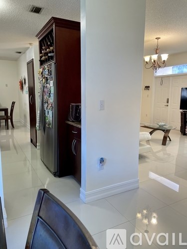 A kitchen with a refrigerator and a dining table.