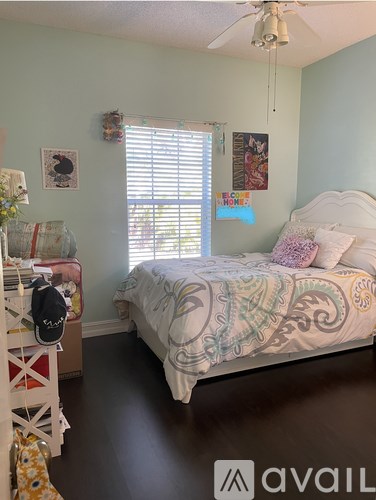 A bedroom with a bed, a dresser, and a ceiling fan.