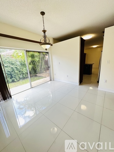 A bedroom with a large bed and a refrigerator in the corner.