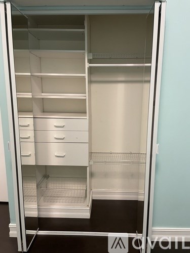 A white open closet with drawers and shelves.