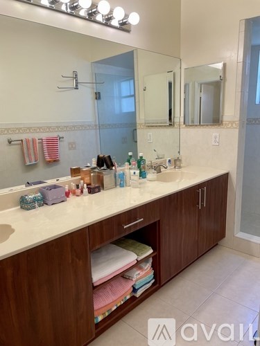 A bathroom with a sink, mirror, and wooden cabinets.