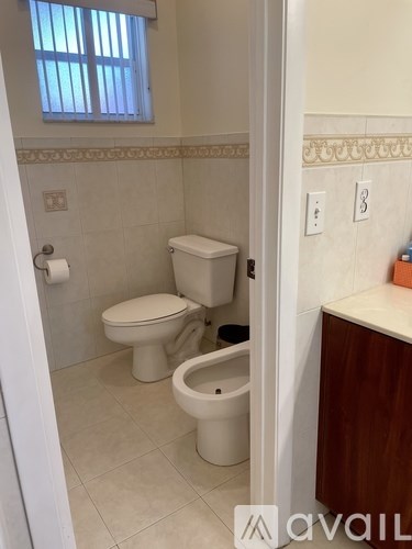 A bathroom with a toilet and a toilet paper roll.