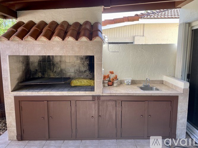 A brick oven with a sink and cabinets below it.