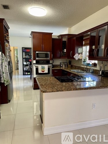 A kitchen with brown cabinets and a granite countertop.
