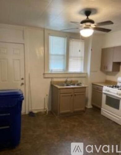 A kitchen with a white stove and a window.