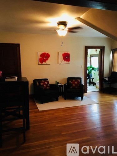 A living room with two black couches and a wooden floor.