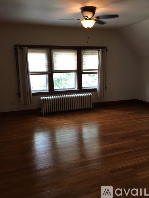A room with a window and a radiator on the floor.