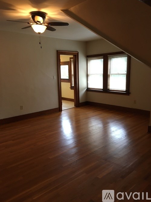 A room with wooden floors and a ceiling fan.