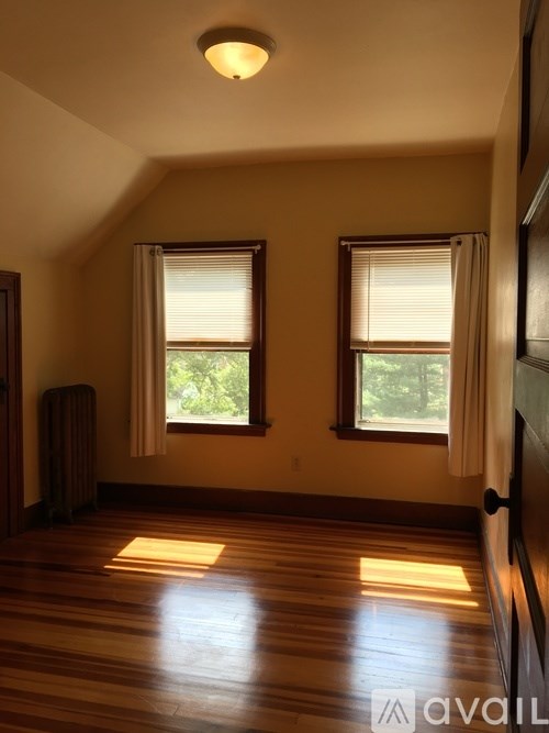A room with wooden floors and two windows.