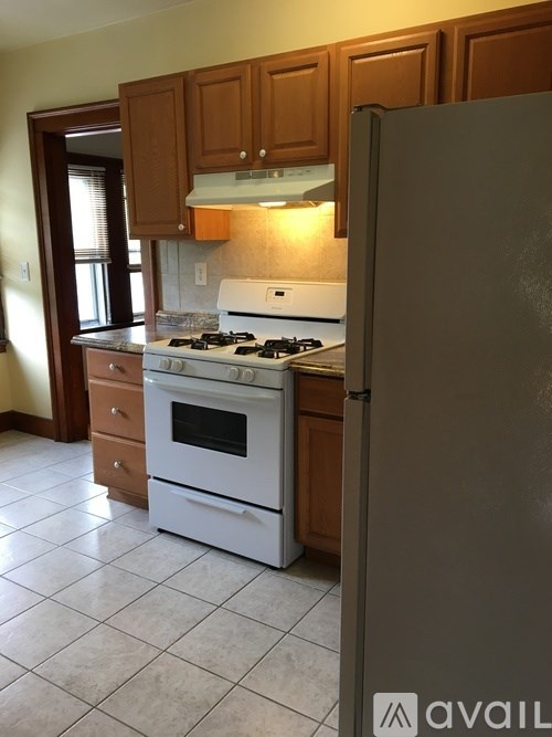 A kitchen with a white stove and a refrigerator.
