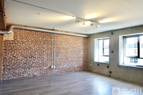 A room with a brick wall and wooden flooring.