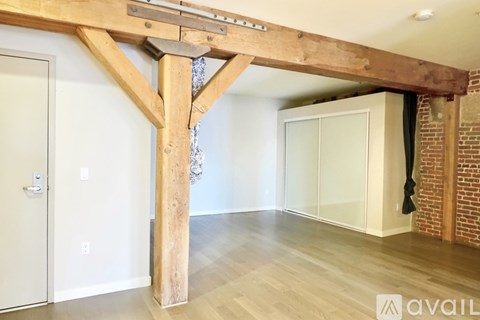 A room with a wooden beam and glass doors.