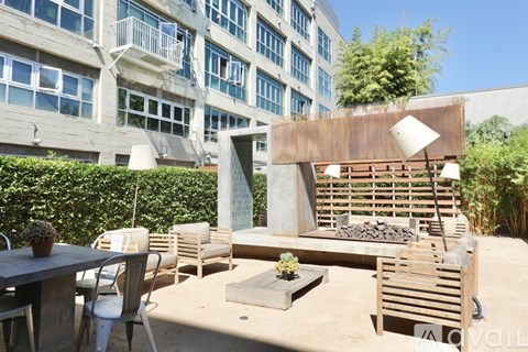 A patio with a table, chairs, and a fire pit.