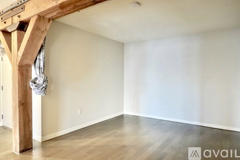 A room with wooden beams and a white wall.