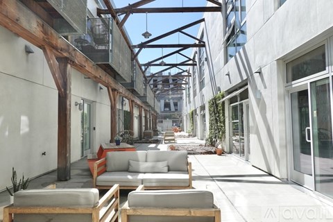 A patio area with wooden beams and furniture.