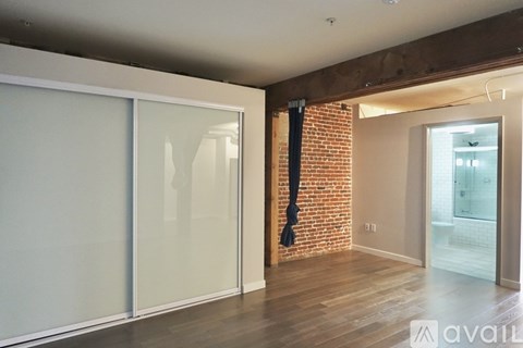 A room with a brick wall and a glass door.