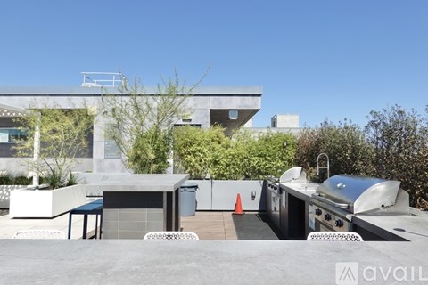 A modern outdoor kitchen area with a grill and seating area.