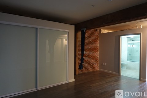A room with a brick wall and wooden flooring.