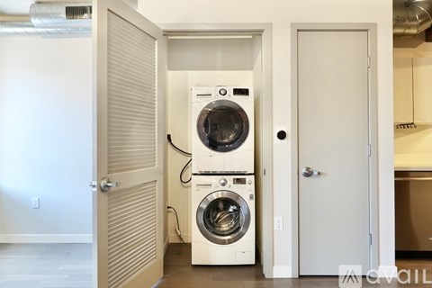 A washer and dryer combo is in a small laundry room.