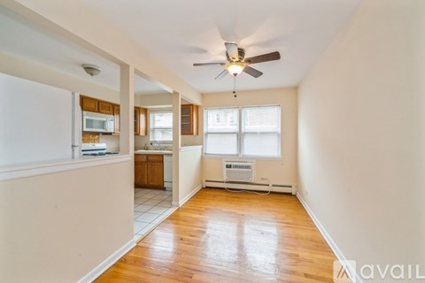 A spacious room with a ceiling fan and hardwood floors.