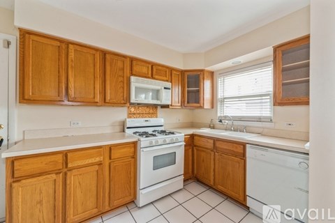 A kitchen with wooden cabinets and white appliances.