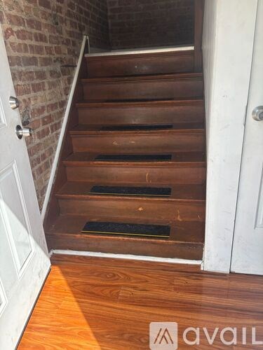 A set of wooden stairs with a white door on the left and a white door on the right.