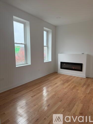 A room with a fireplace and two windows.