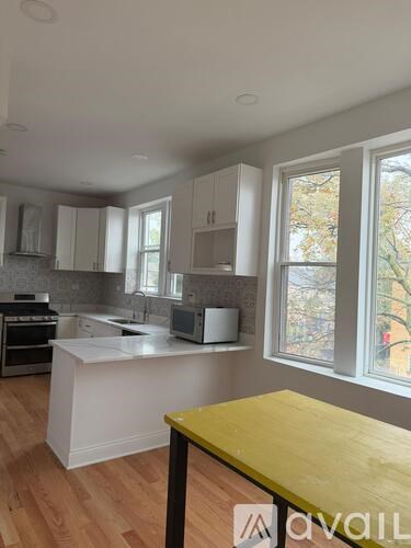 A kitchen with white cabinets and a yellow table.