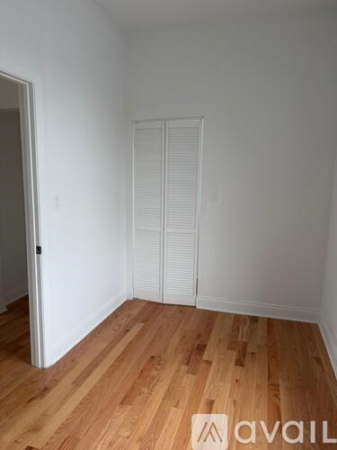 A room with wooden flooring and white walls.