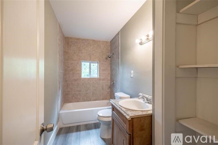 A bathroom with a tub, toilet, and sink.