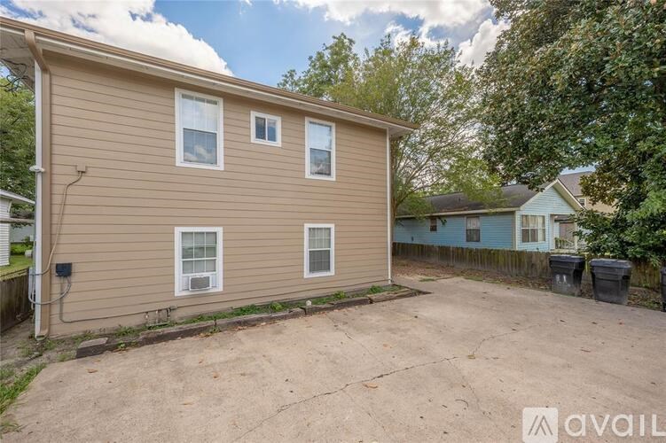 A beige house with a brown roof and a brown fence.