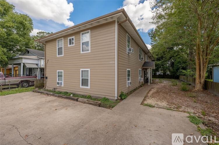 A beige house with a driveway in front of it.