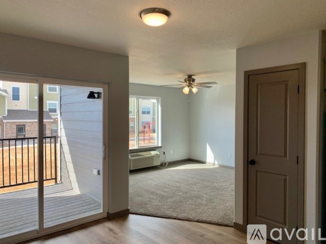 A room with a ceiling fan and a door leading to a balcony.