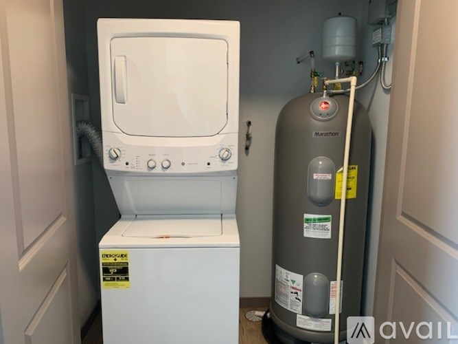 A tankless water heater is installed next to a wall-mounted tank.