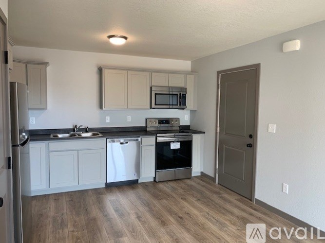 A kitchen with white cabinets and a wooden floor.