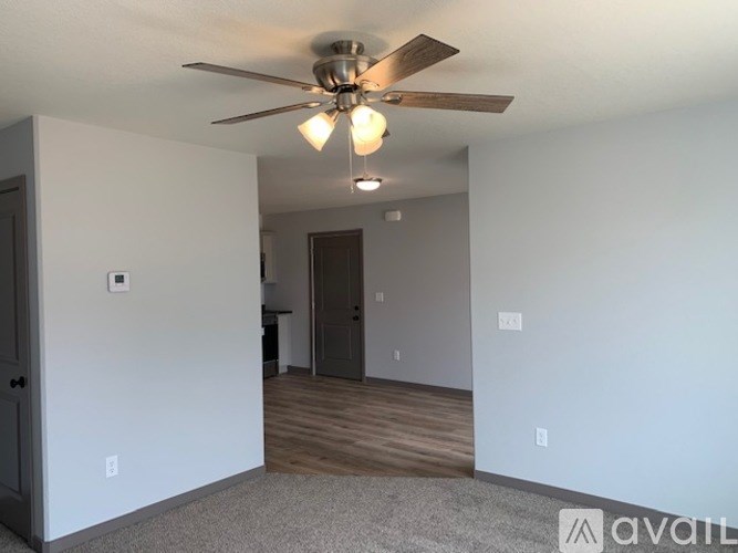 A room with a ceiling fan and a light fixture.