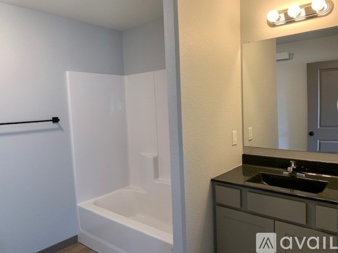 A bathroom with a white tub and sink.