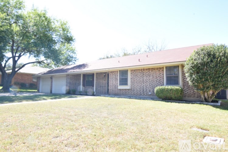 A house with a red roof and a white fence.