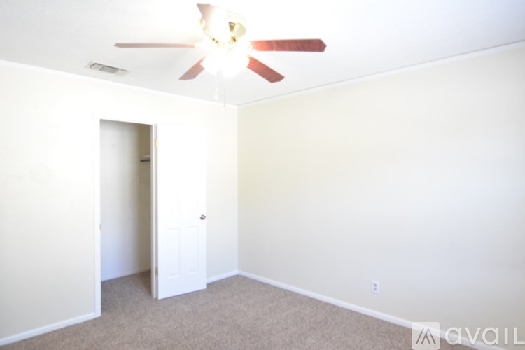 A room with a ceiling fan and a carpeted floor.